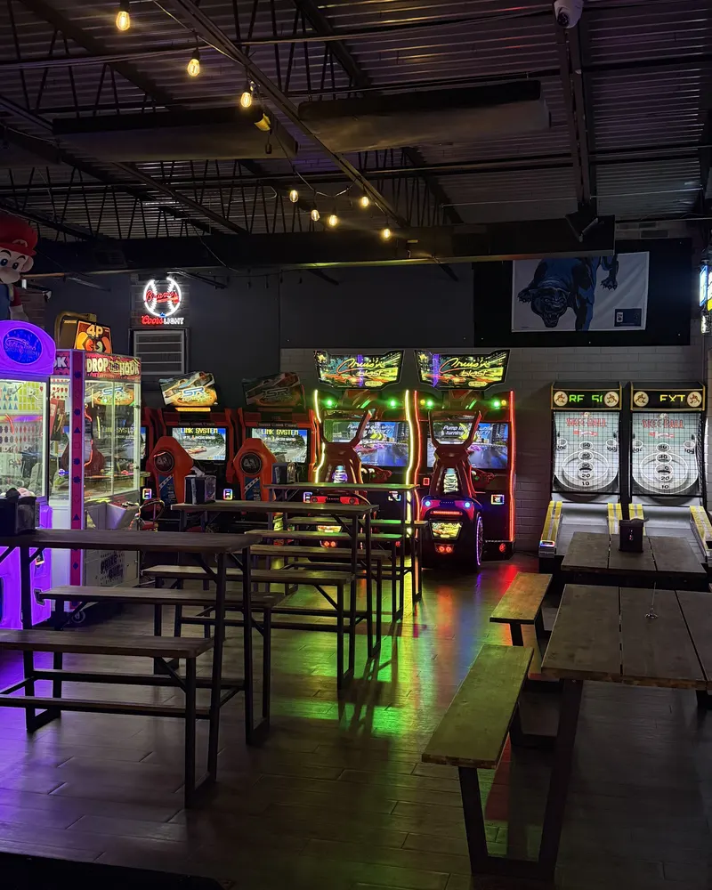 Game floor with picnic-style tables, claw machines, racers and Skee-Ball lanes